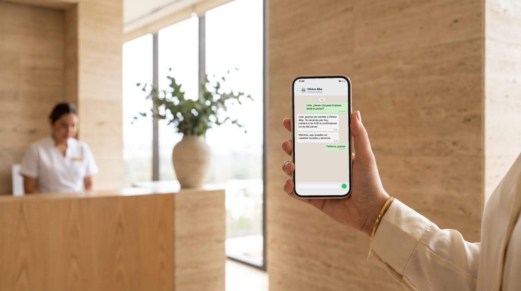 Una clienta lee en su teléfono la respuesta automática que le mandó por WhatsApp la clínica donde quiere agendar